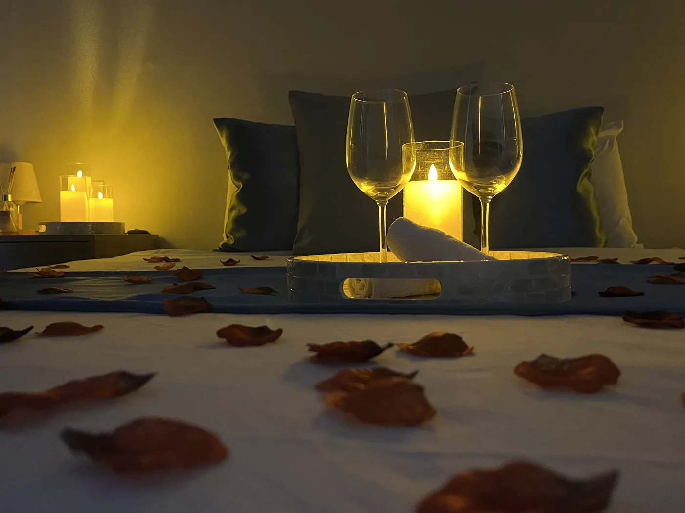 Deux verres et une bougie sur le lit, à la lueur des bougies